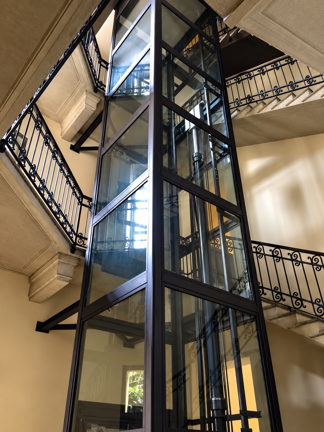 Ascensore esterno vetrato installato lungo la facciata di un edificio storico