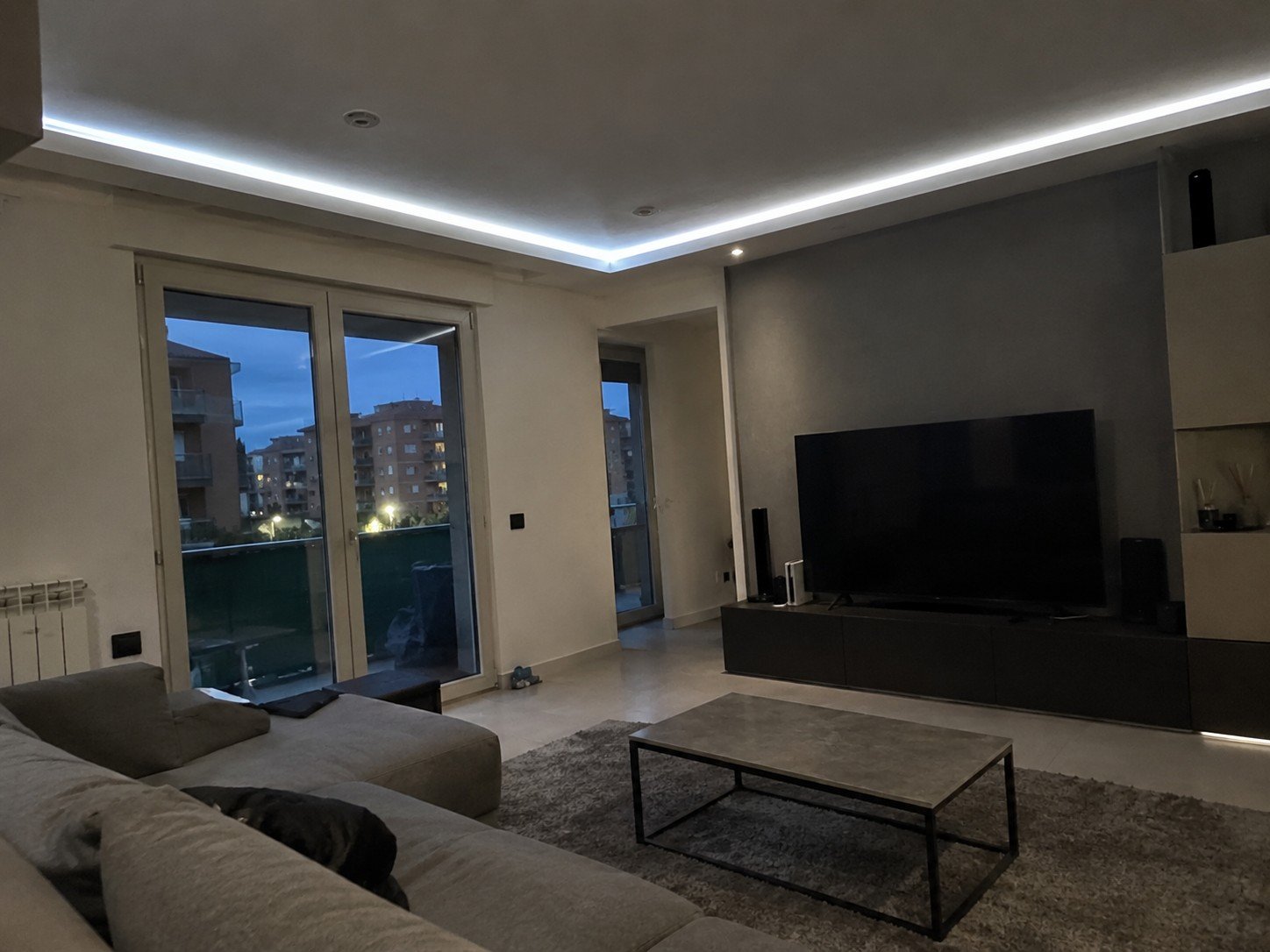Soggiorno moderno con impianto elettrico LED, strisce di luce e illuminazione d'ambiente