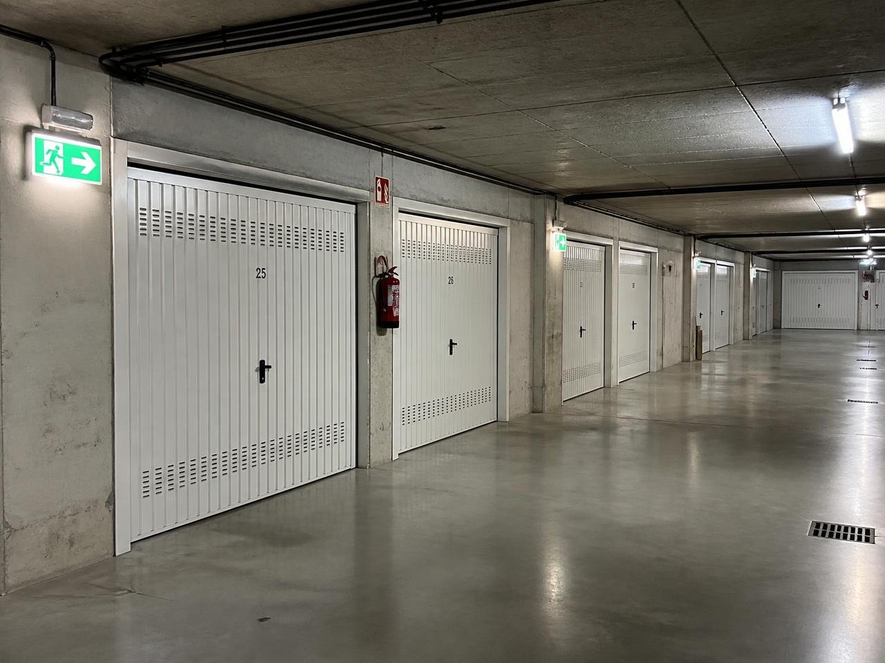 Lampade di emergenza e segnaletica di uscita installate nei box di un'autorimessa condominiale