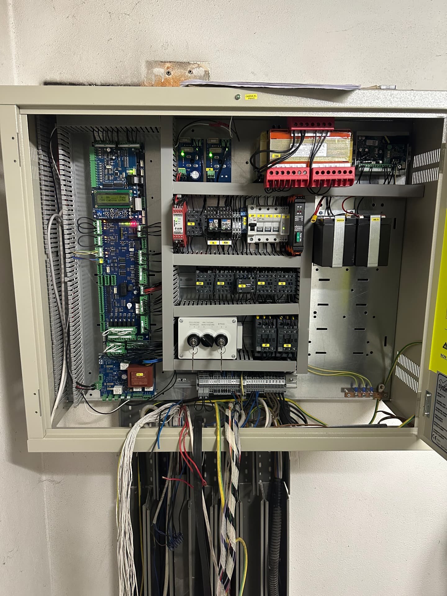 Quadro di manovra ascensore aperto con schede elettroniche, contattori e cablaggi